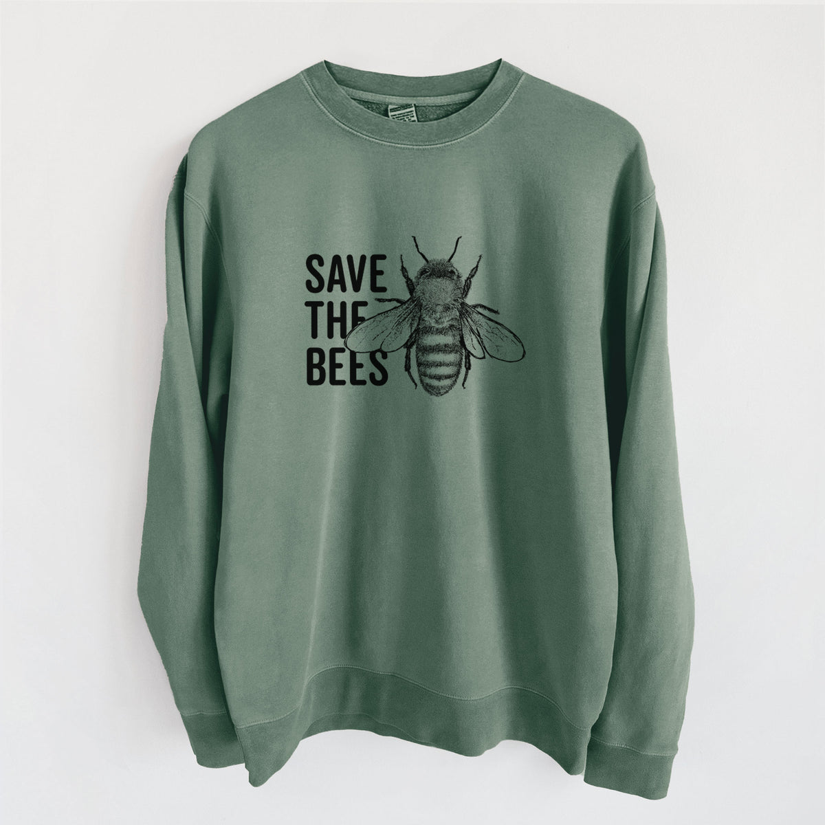 Alpine green pigment dyed crewneck sweatshirt laid flat, printed with bold black words reading Save the Bees beside a detailed honey bee illustration.