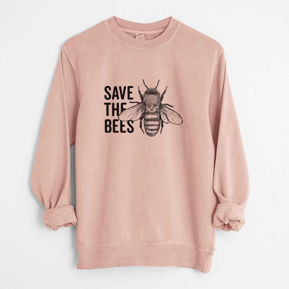 Dusty pink pigment dyed crewneck sweatshirt laid flat with the sleeves rolled, printed with bold black words reading Save the Bees beside a detailed honey bee illustration.