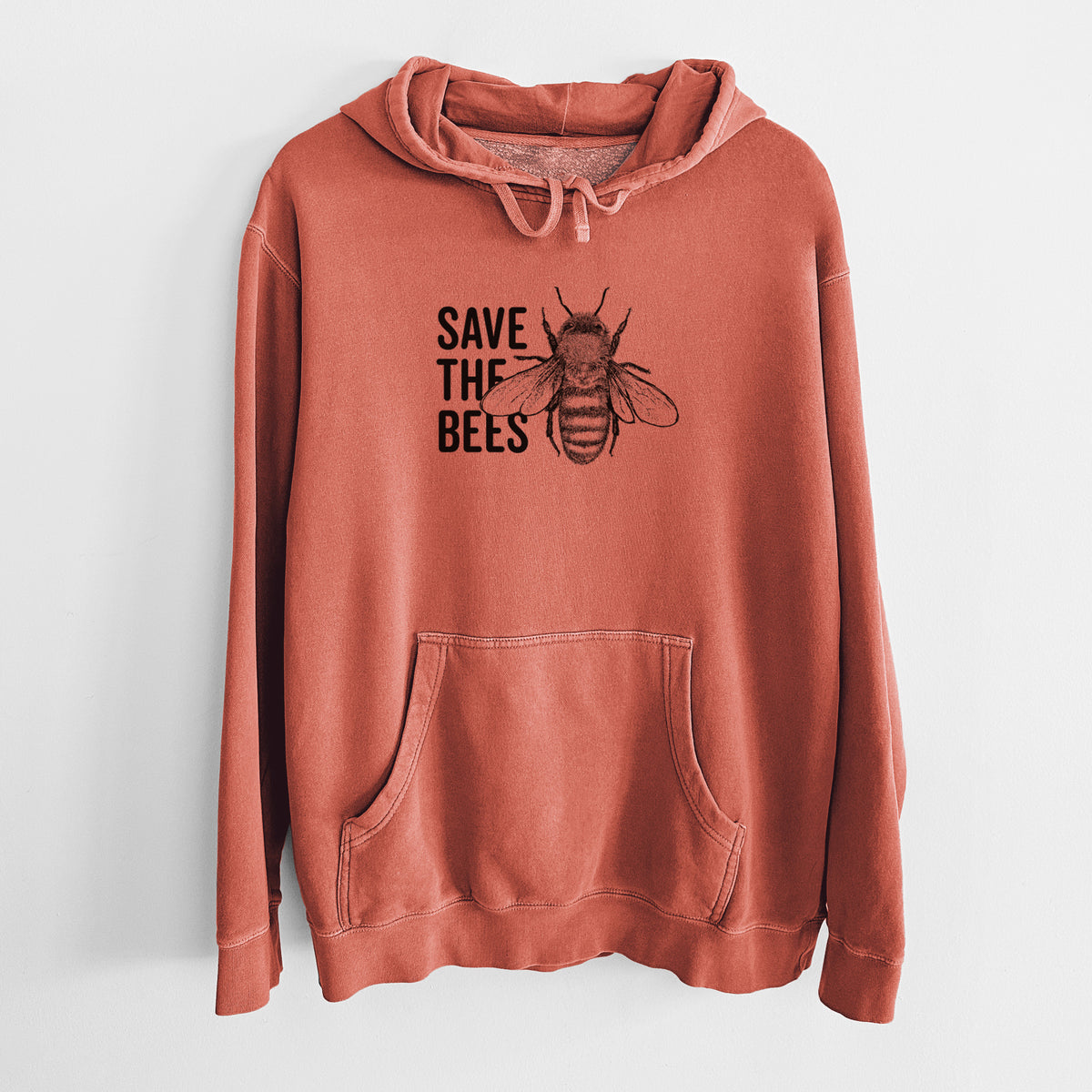 Amber orange pigment dyed hoodie laid flat, printed with bold black words reading Save the Bees beside a detailed honey bee illustration.