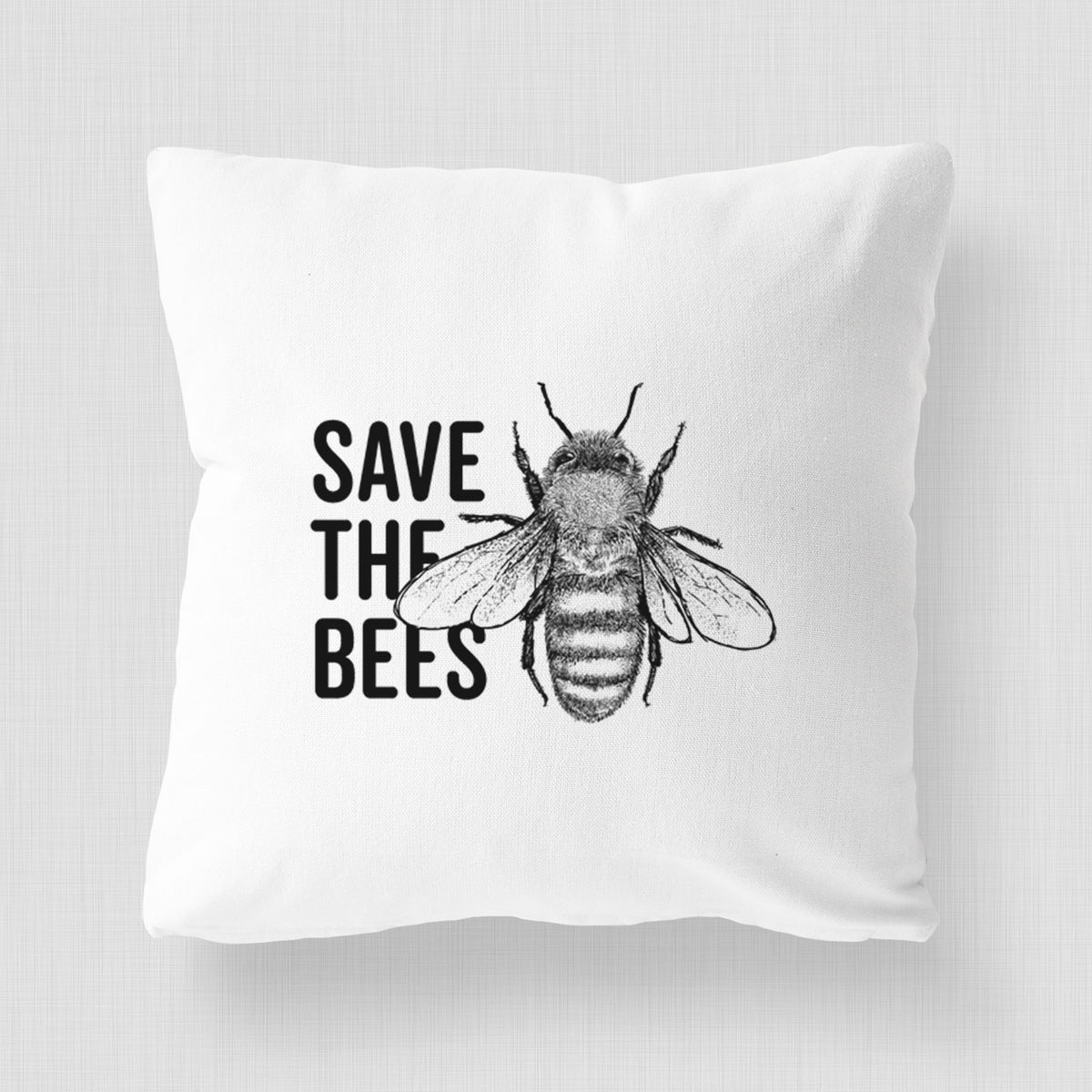 White pillow cover printed with bold black words reading Save the Bees beside a detailed honey bee illustration.