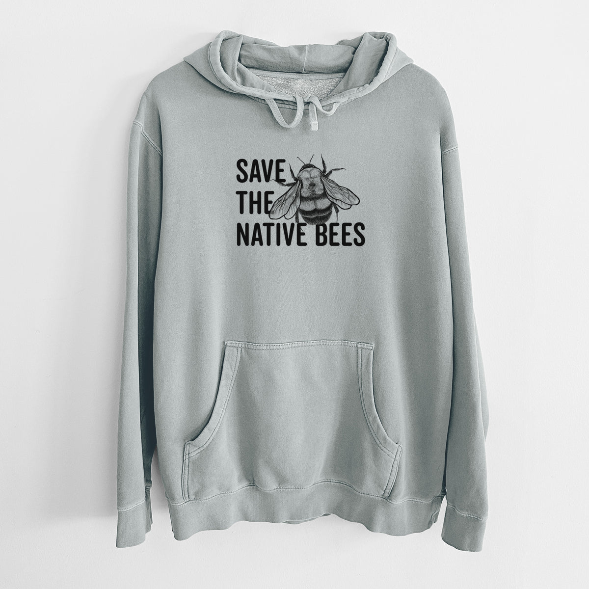 Sage green pigment dyed hoodie laid flat, printed with bold black words reading Save the Native Bees beside a detailed bee illustration.