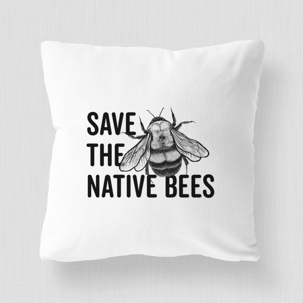 White pillow cover printed with bold black words reading Save the Native Bees beside a detailed bee illustration.
