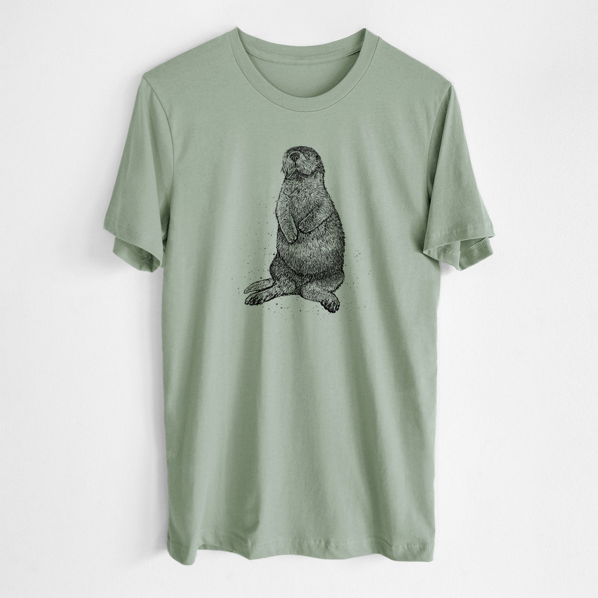 Sage green lightweight cotton t-shirt laid flat, printed with a detailed black ink illustration of a sea otter sitting upright.