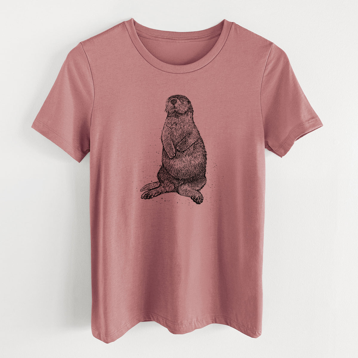 Mauve pink women's relaxed fit cotton t-shirt laid flat, printed with a detailed black ink illustration of a sea otter sitting upright.