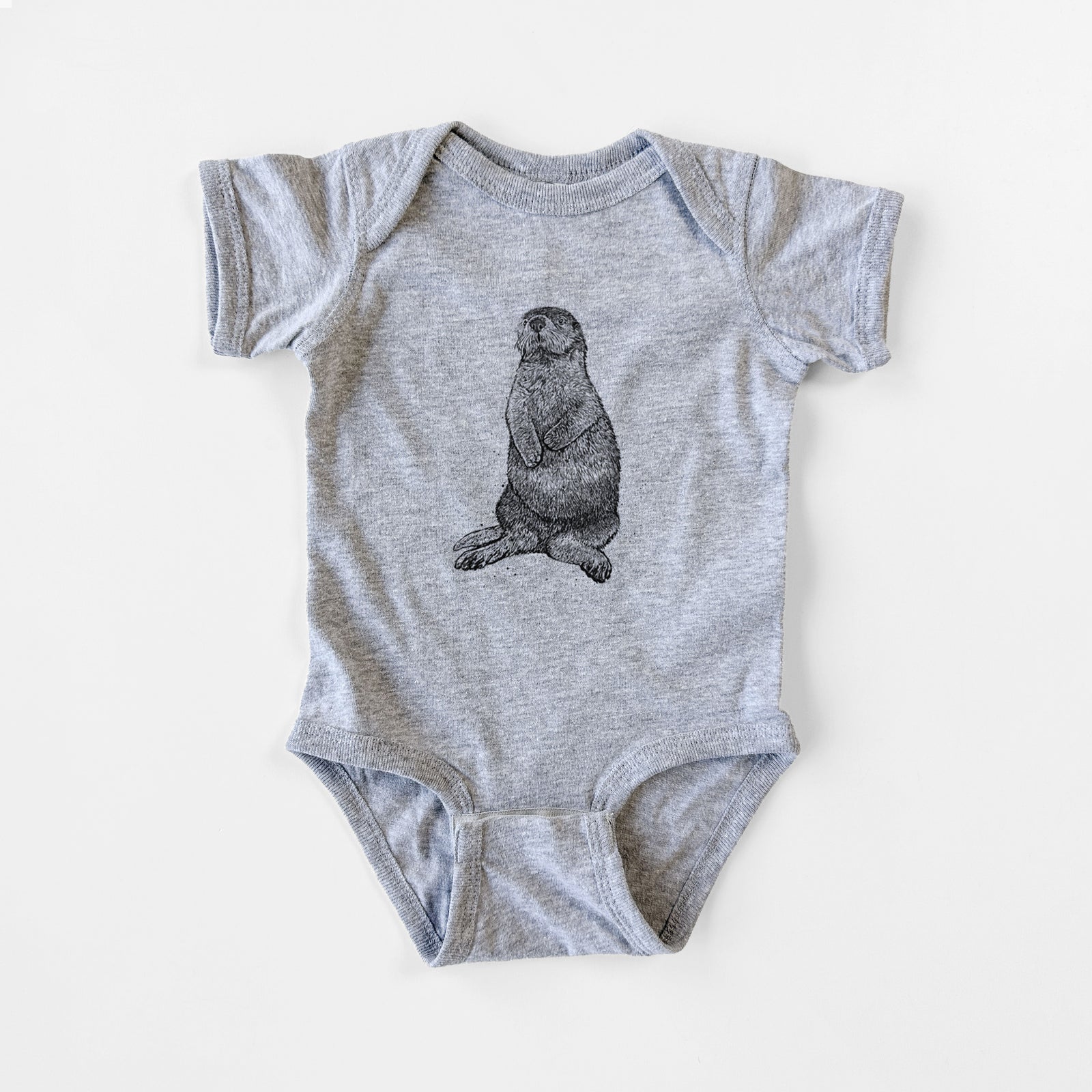 Grey baby bodysuit laid flat, printed with a detailed black ink illustration of a sea otter sitting upright.