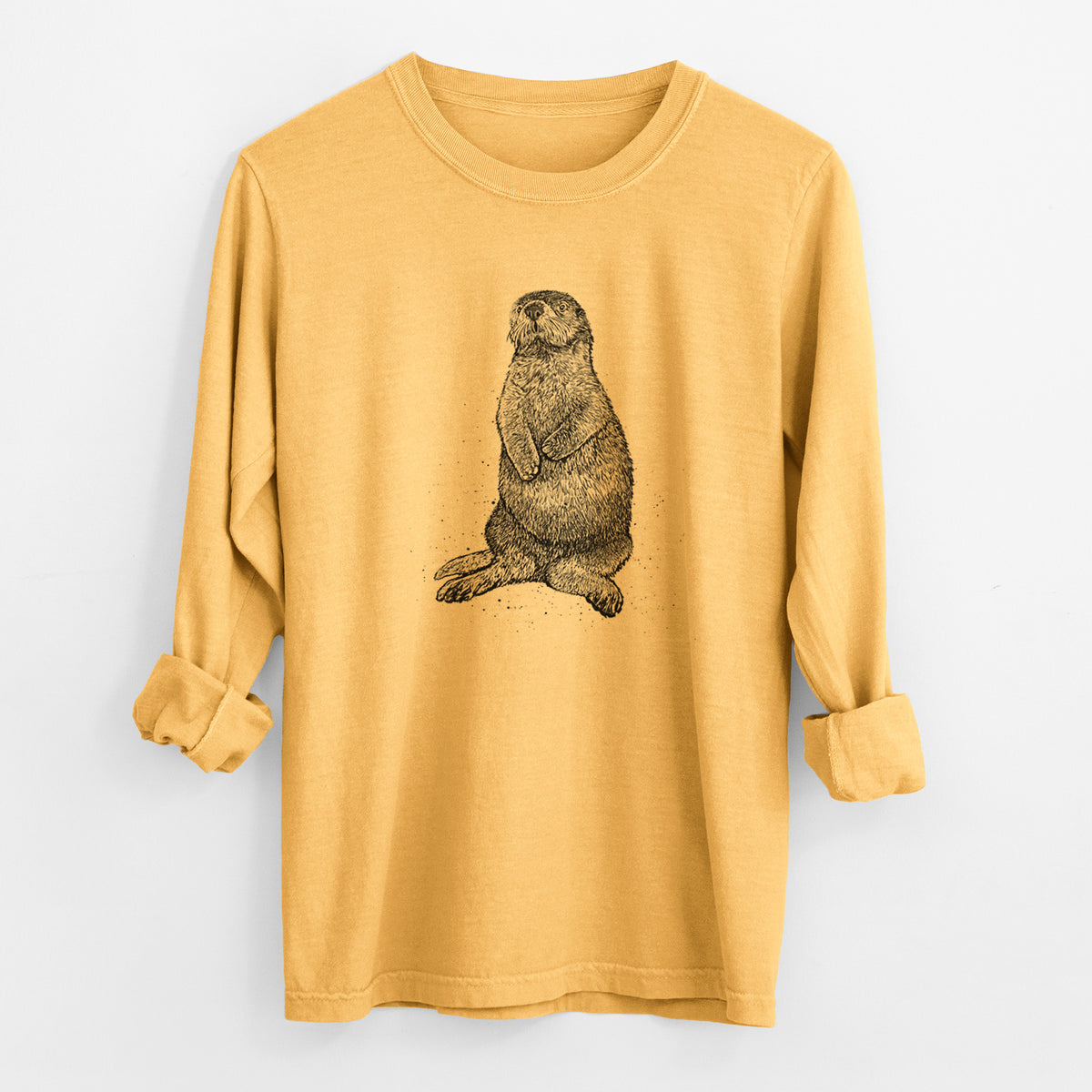 Golden wheat yellow Comfort Colors long sleeve shirt laid flat with the cuffs rolled, printed with a detailed black ink illustration of a sea otter sitting upright.