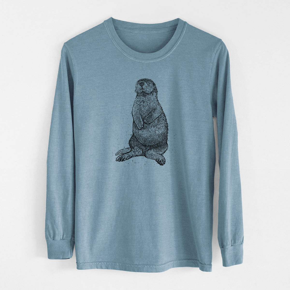 Steel blue Comfort Colors long sleeve shirt laid flat, printed with a detailed black ink illustration of a sea otter sitting upright.