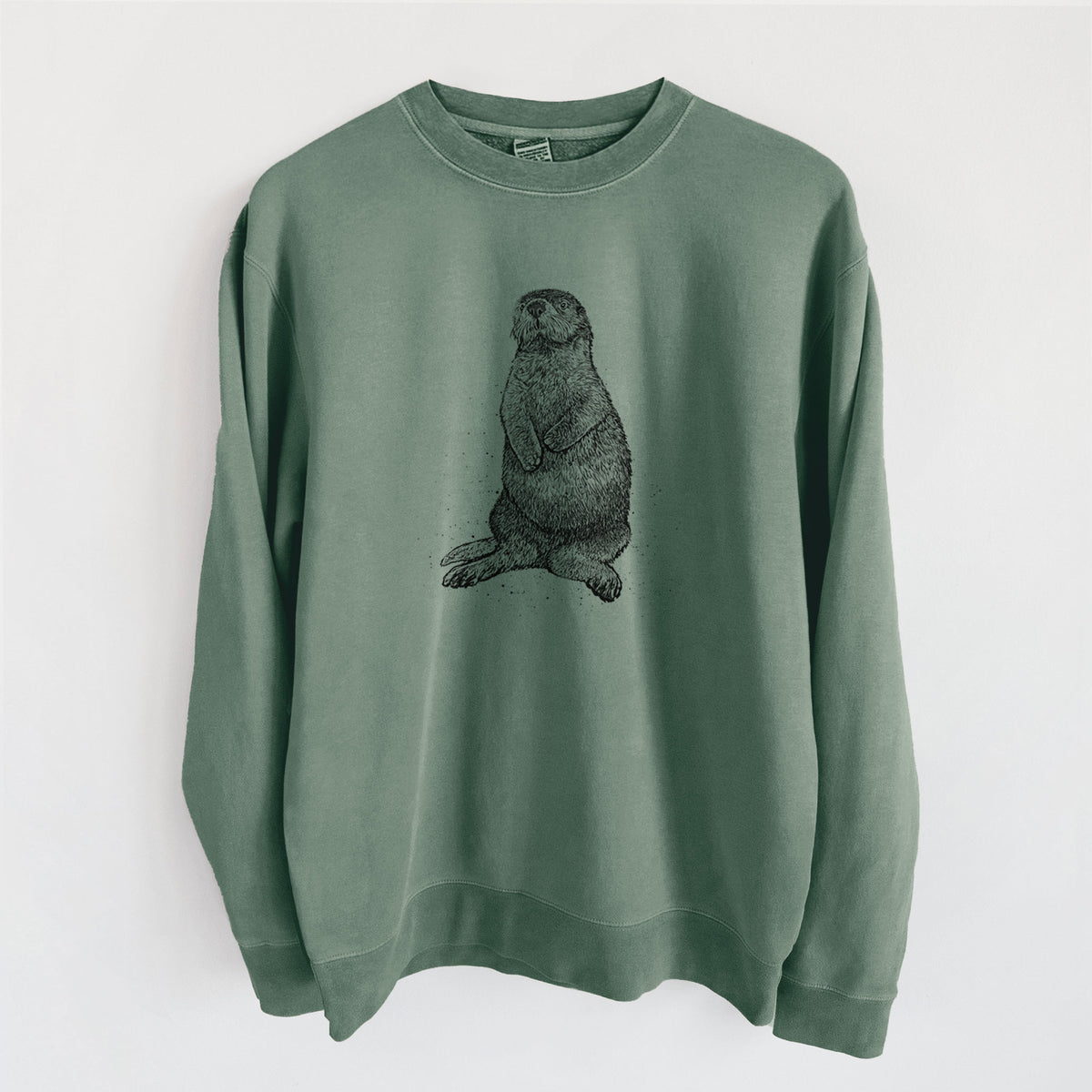 Alpine green pigment dyed crewneck sweatshirt laid flat, printed with a detailed black ink illustration of a sea otter sitting upright.