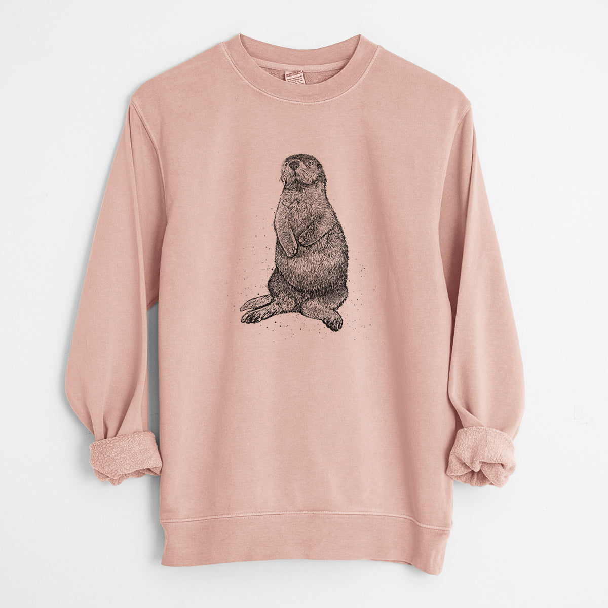 Dusty pink pigment dyed crewneck sweatshirt laid flat with the sleeves rolled, printed with a detailed black ink illustration of a sea otter sitting upright.