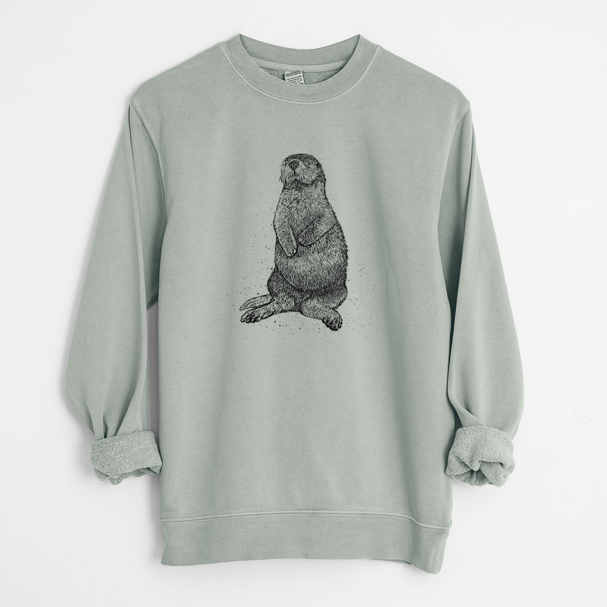 Sage green pigment dyed crewneck sweatshirt laid flat with the sleeves rolled, printed with a detailed black ink illustration of a sea otter sitting upright.