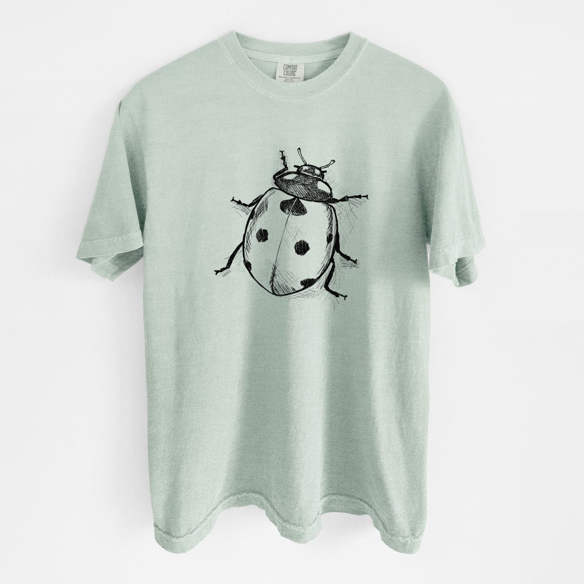Bay green Comfort Colors t-shirt laid flat, printed with a detailed black ink illustration of a seven-spot ladybird beetle.