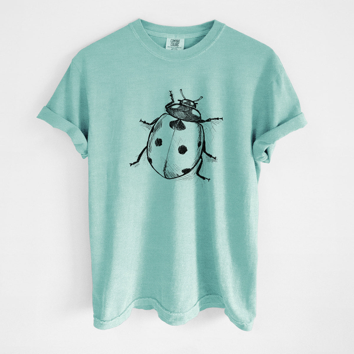 Chalky mint Comfort Colors t-shirt laid flat, printed with a detailed black ink illustration of a seven-spot ladybird beetle.