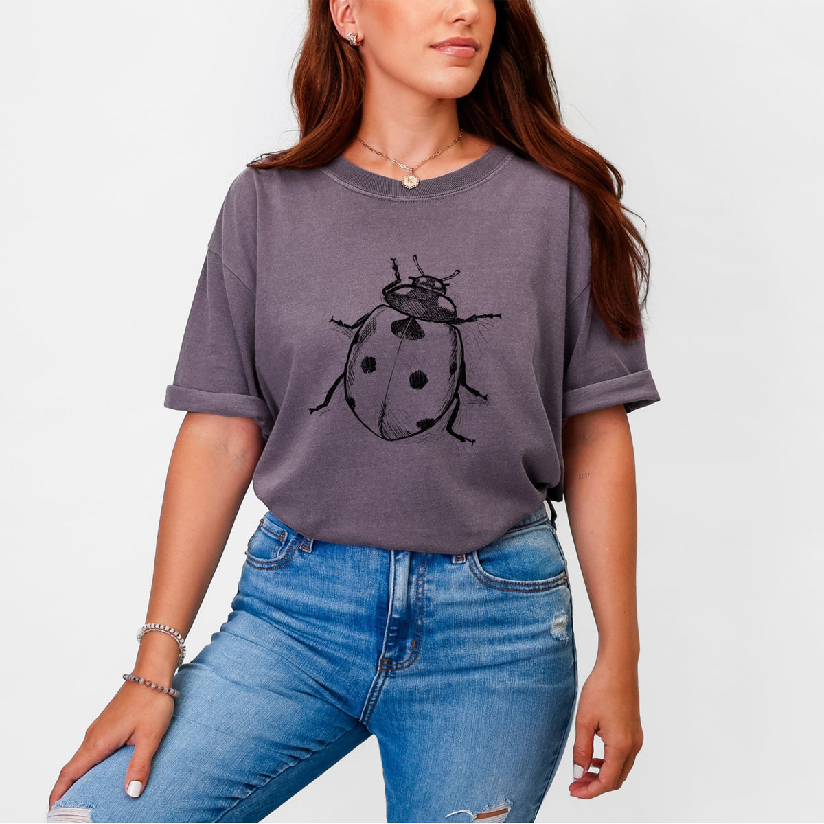 Woman wearing a Comfort Colors t-shirt printed with a detailed black ink illustration of a seven-spot ladybird beetle.