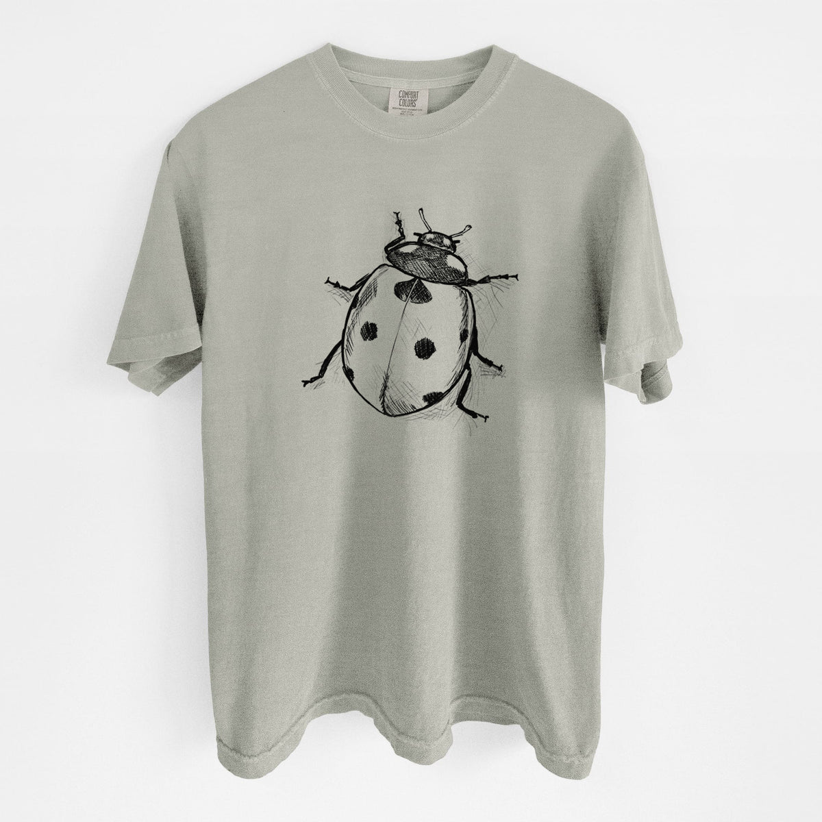 Sandstone beige Comfort Colors t-shirt laid flat, printed with a detailed black ink illustration of a seven-spot ladybird beetle.
