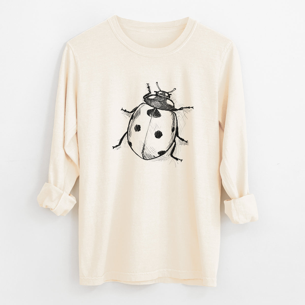 Ivory Comfort Colors long sleeve shirt laid flat with the cuffs rolled, printed with a detailed black ink illustration of a seven-spot ladybird beetle.