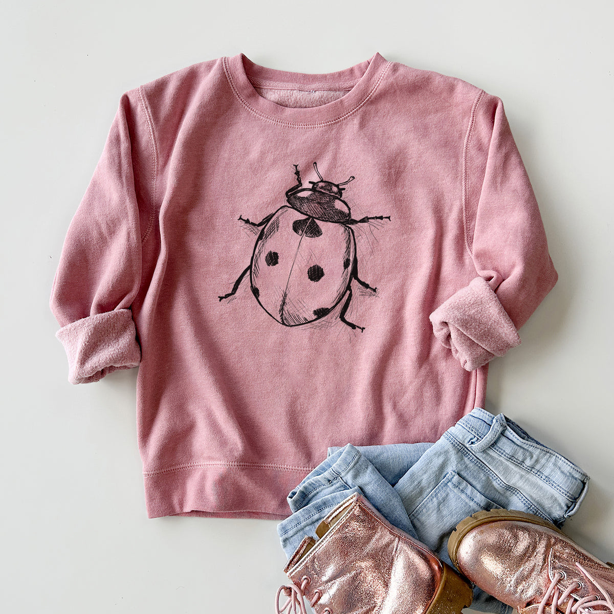 Youth crewneck sweatshirt printed with a detailed black ink illustration of a seven-spot ladybird beetle, styled flat with jeans and boots.