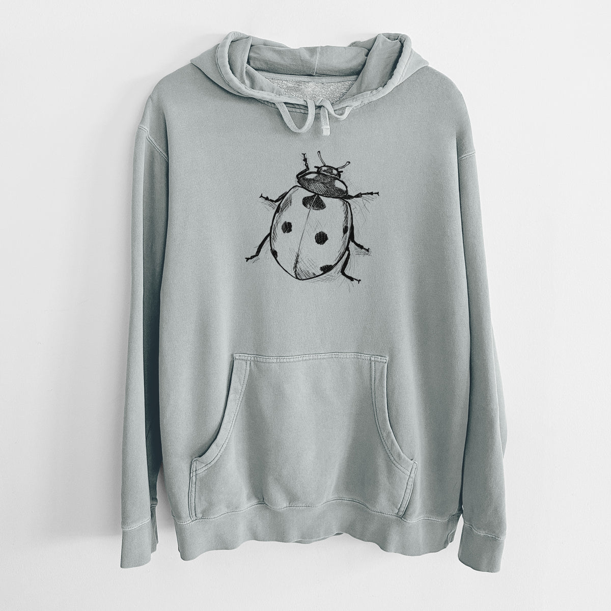 Sage green pigment dyed hoodie laid flat, printed with a detailed black ink illustration of a seven-spot ladybird beetle.