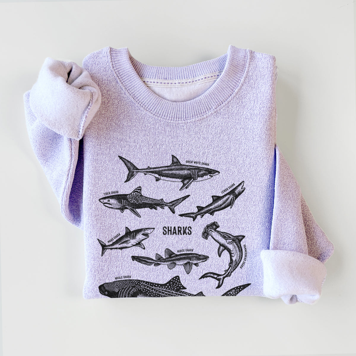 Ice purple knit sweatshirt printed with a chart of black ink shark illustrations, including a whale shark, hammerhead and great white, styled flat.