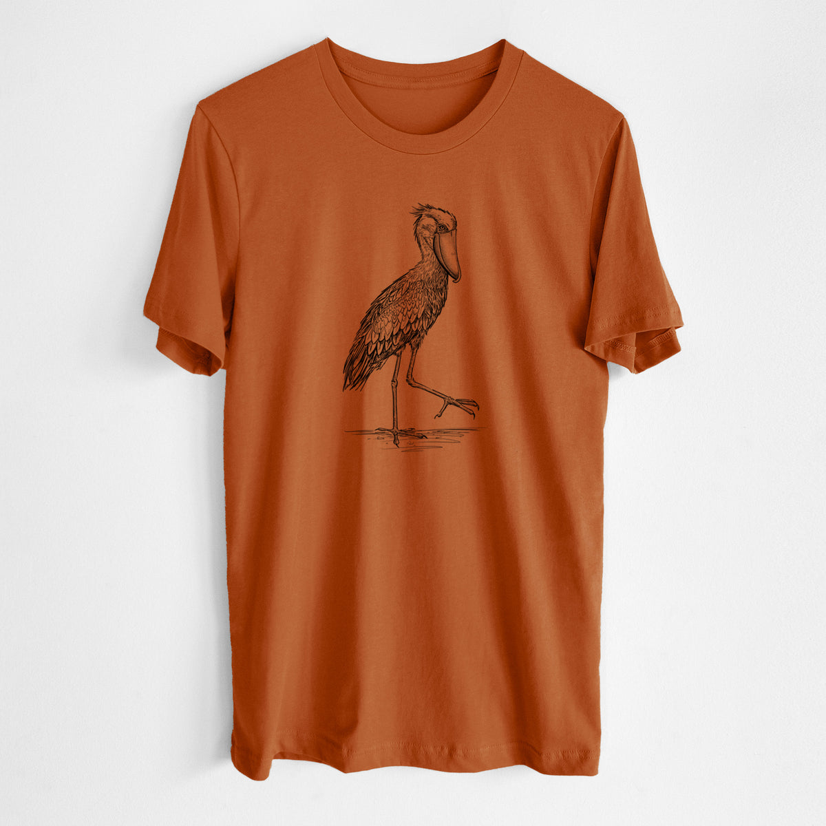Autumn lightweight cotton t-shirt laid flat, printed with a black ink illustration of a shoebill stork standing on one leg.