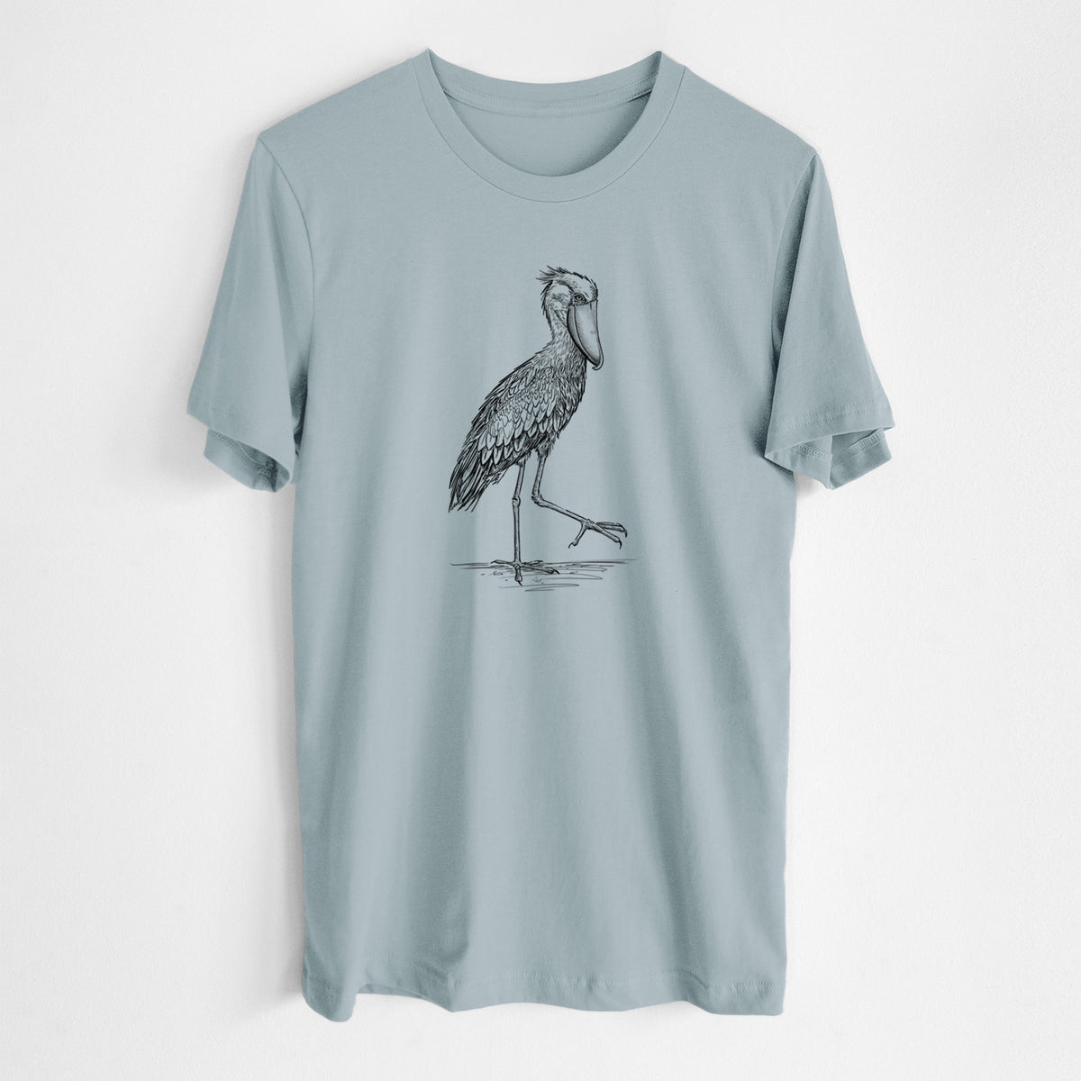 Vintage denim lightweight cotton t-shirt laid flat, printed with a black ink illustration of a shoebill stork standing on one leg.