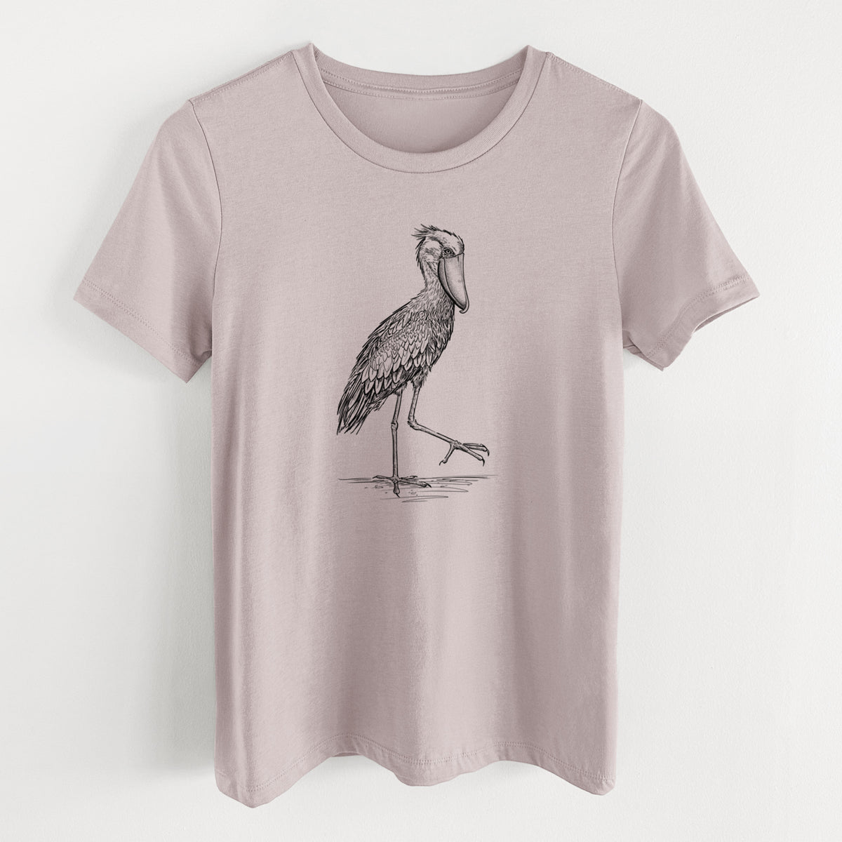 Pink gravel women's relaxed fit cotton t-shirt laid flat, printed with a black ink illustration of a shoebill stork standing on one leg.