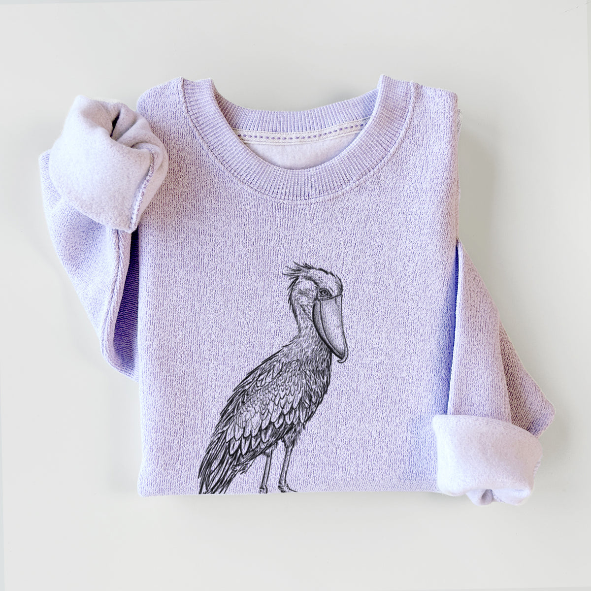 Ice purple knit sweatshirt printed with a black ink illustration of a shoebill stork standing on one leg, styled flat.