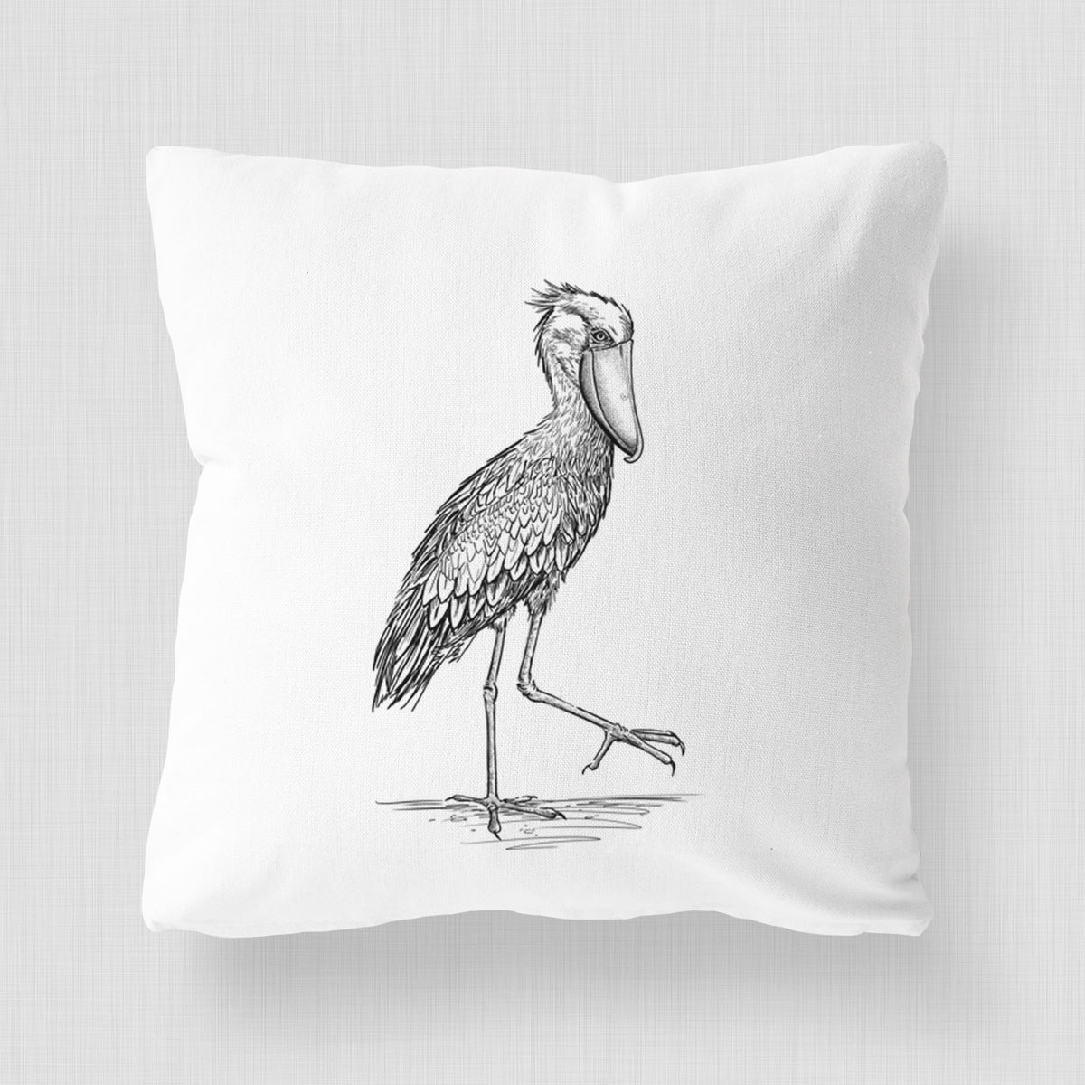 White pillow cover printed with a black ink illustration of a shoebill stork standing on one leg.