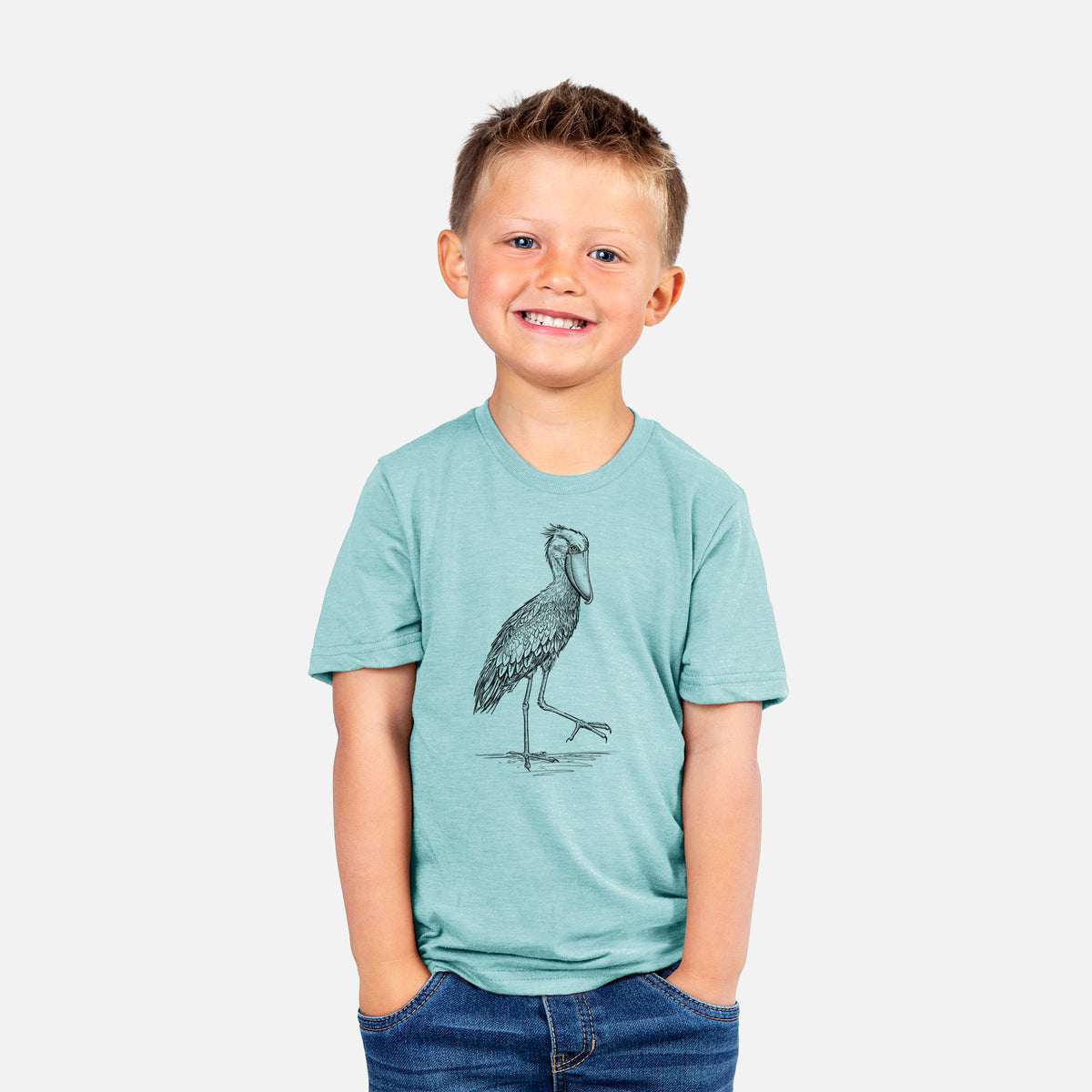 Smiling boy wearing a youth t-shirt printed with a black ink illustration of a shoebill stork standing on one leg.