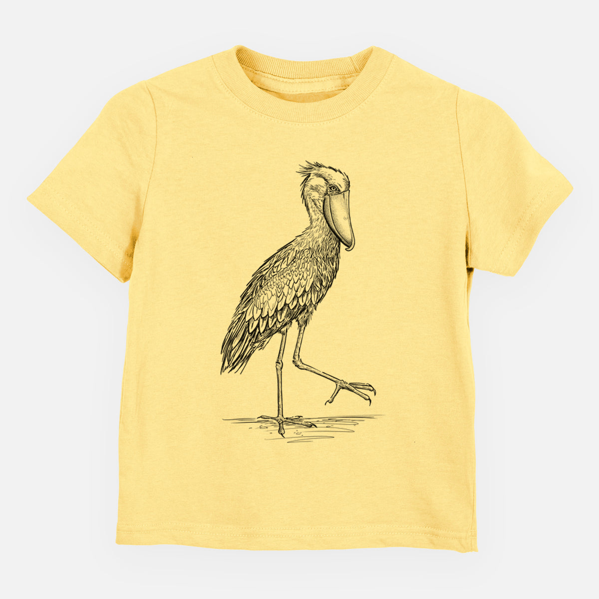 Butter yellow toddler t-shirt laid flat, printed with a black ink illustration of a shoebill stork standing on one leg.