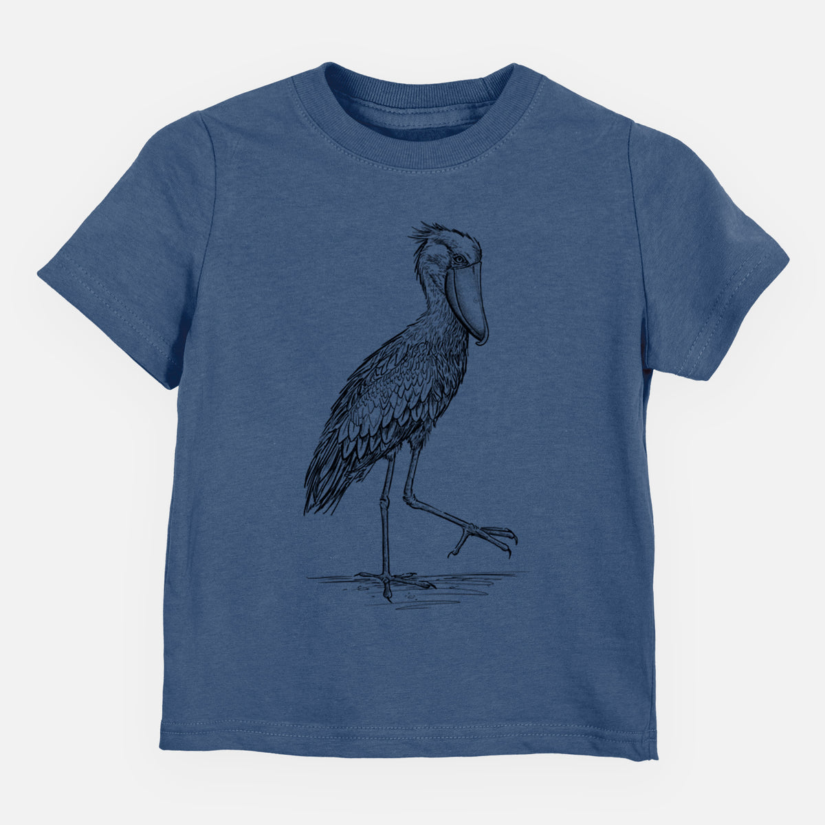 Indigo blue toddler t-shirt laid flat, printed with a black ink illustration of a shoebill stork standing on one leg.