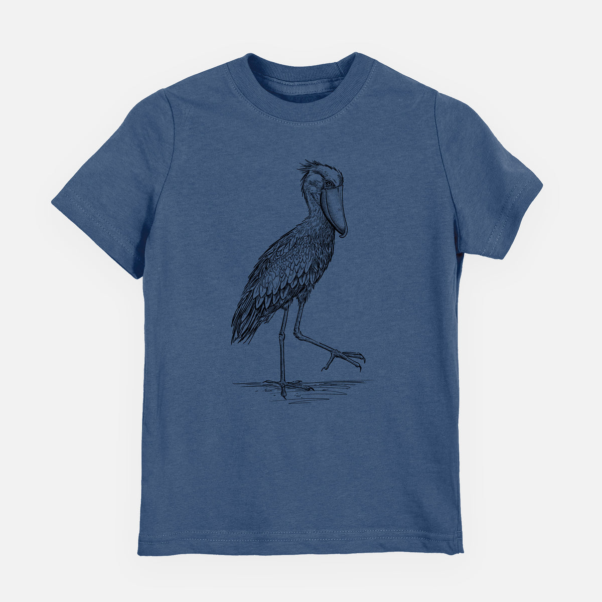 Indigo blue youth t-shirt laid flat, printed with a black ink illustration of a shoebill stork standing on one leg.