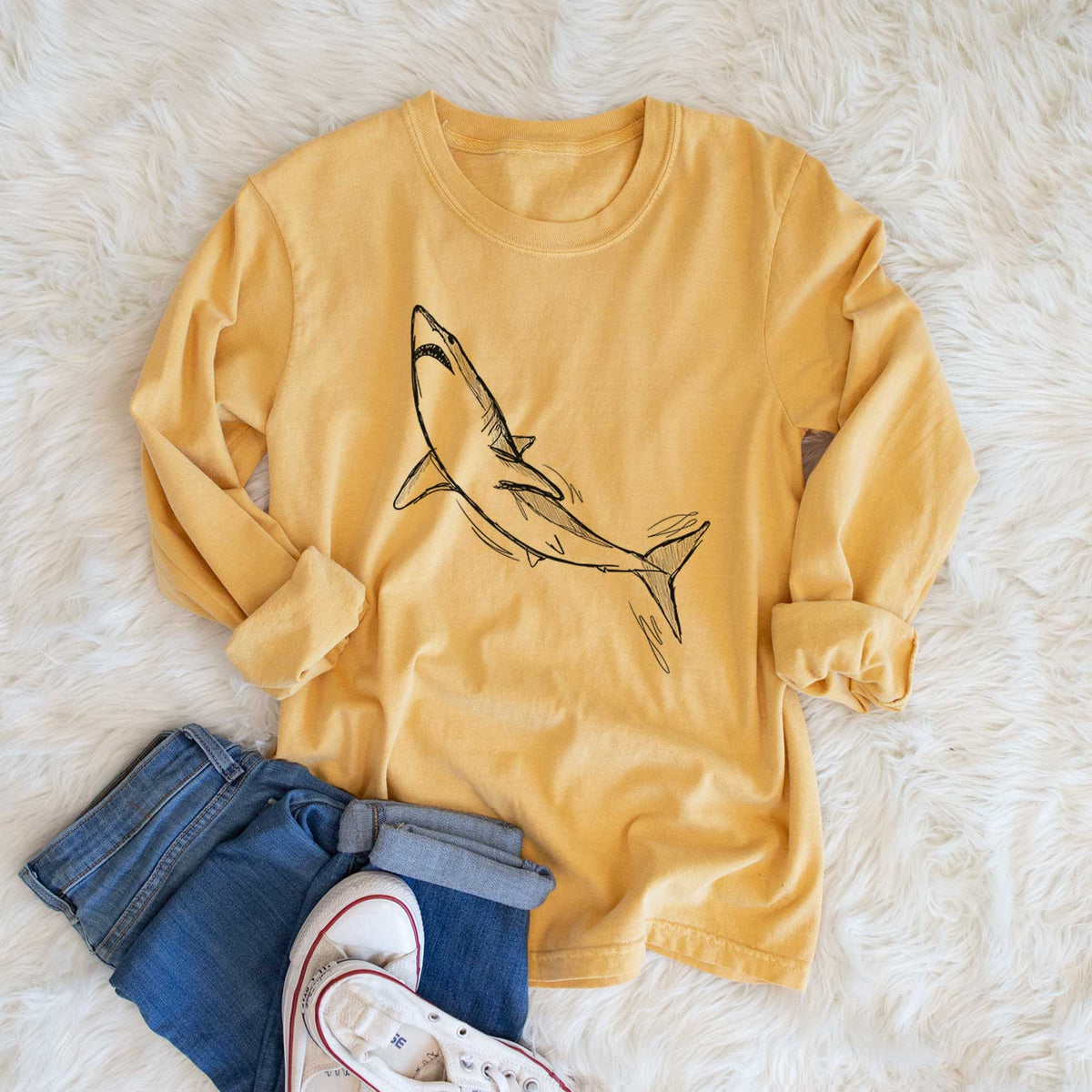 Golden wheat yellow Comfort Colors long sleeve shirt printed with a black ink illustration of a shortfin mako shark diving, shown in a lifestyle photo.