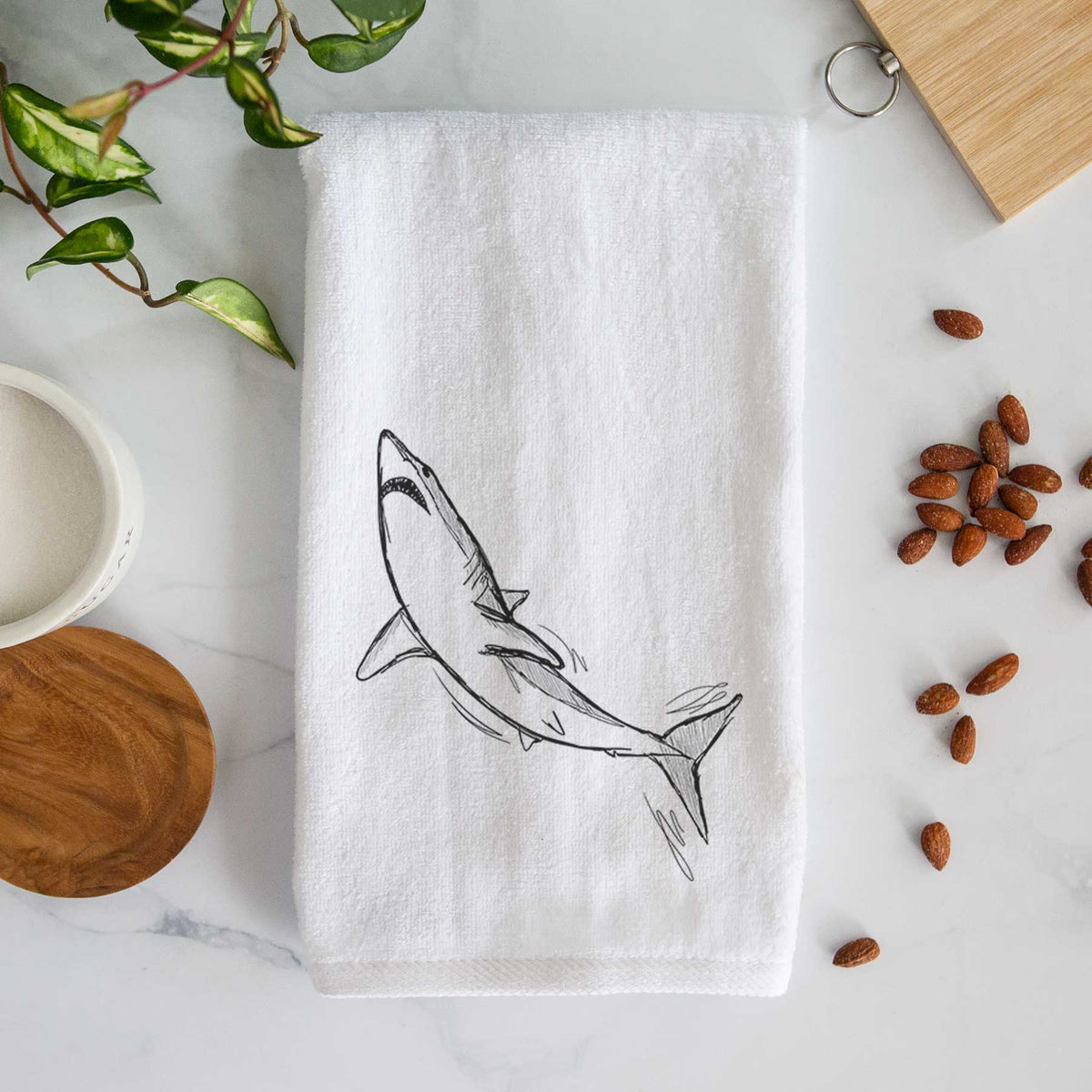 White hand towel printed with a black ink illustration of a shortfin mako shark diving.