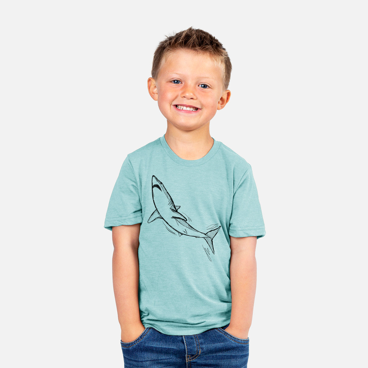 Smiling boy wearing a youth t-shirt printed with a black ink illustration of a shortfin mako shark diving.