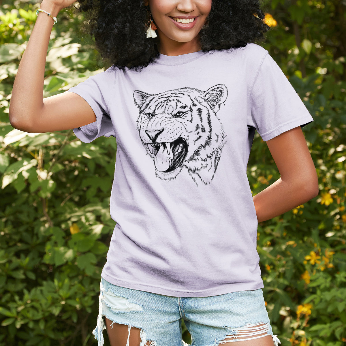 Woman wearing a Comfort Colors t-shirt printed with a detailed black ink portrait of a roaring Siberian tiger, outdoors.