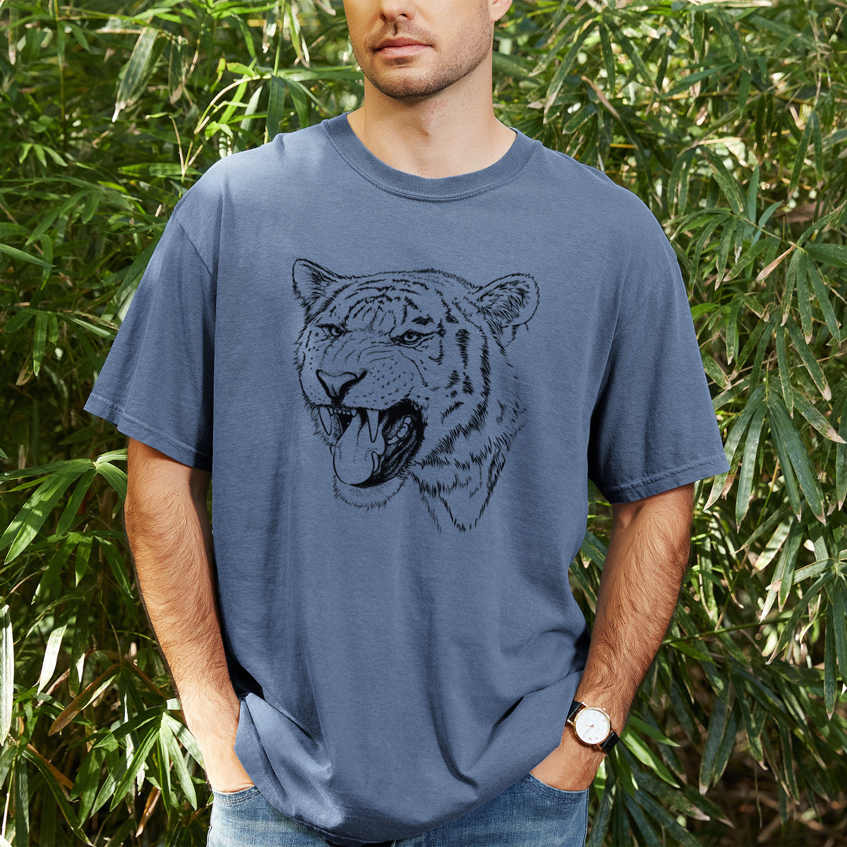 Man wearing a Comfort Colors t-shirt printed with a detailed black ink portrait of a roaring Siberian tiger, outdoors.