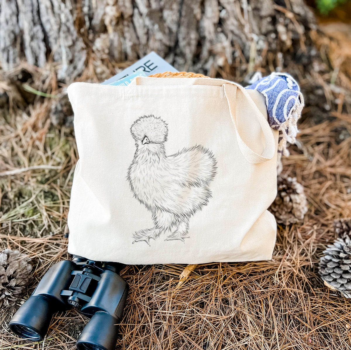 Canvas tote bag printed with a black ink illustration of a fluffy silkie chicken, resting on dry grass beside a pair of binoculars.