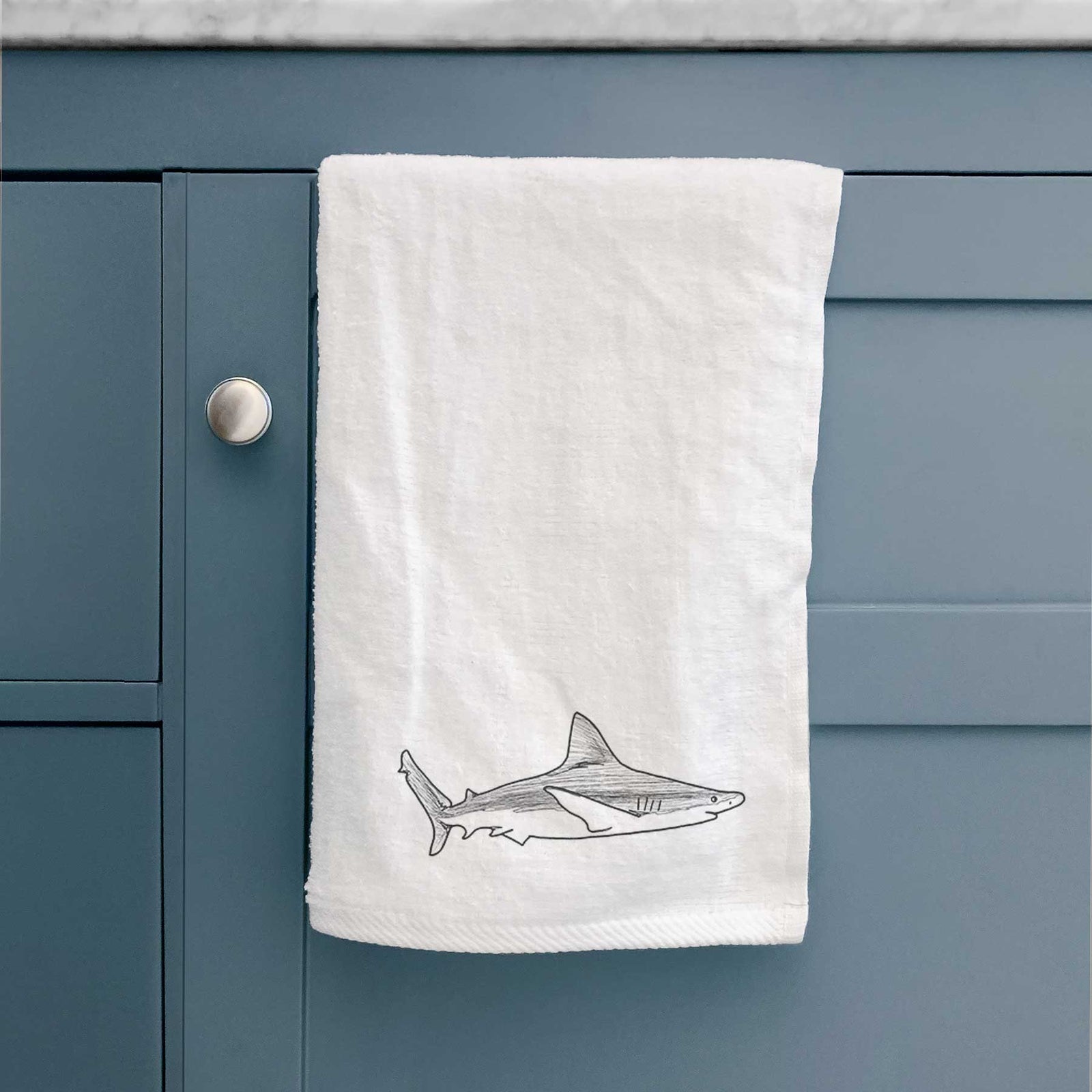 White hand towel printed with a black ink illustration of a silvertip shark swimming in profile.