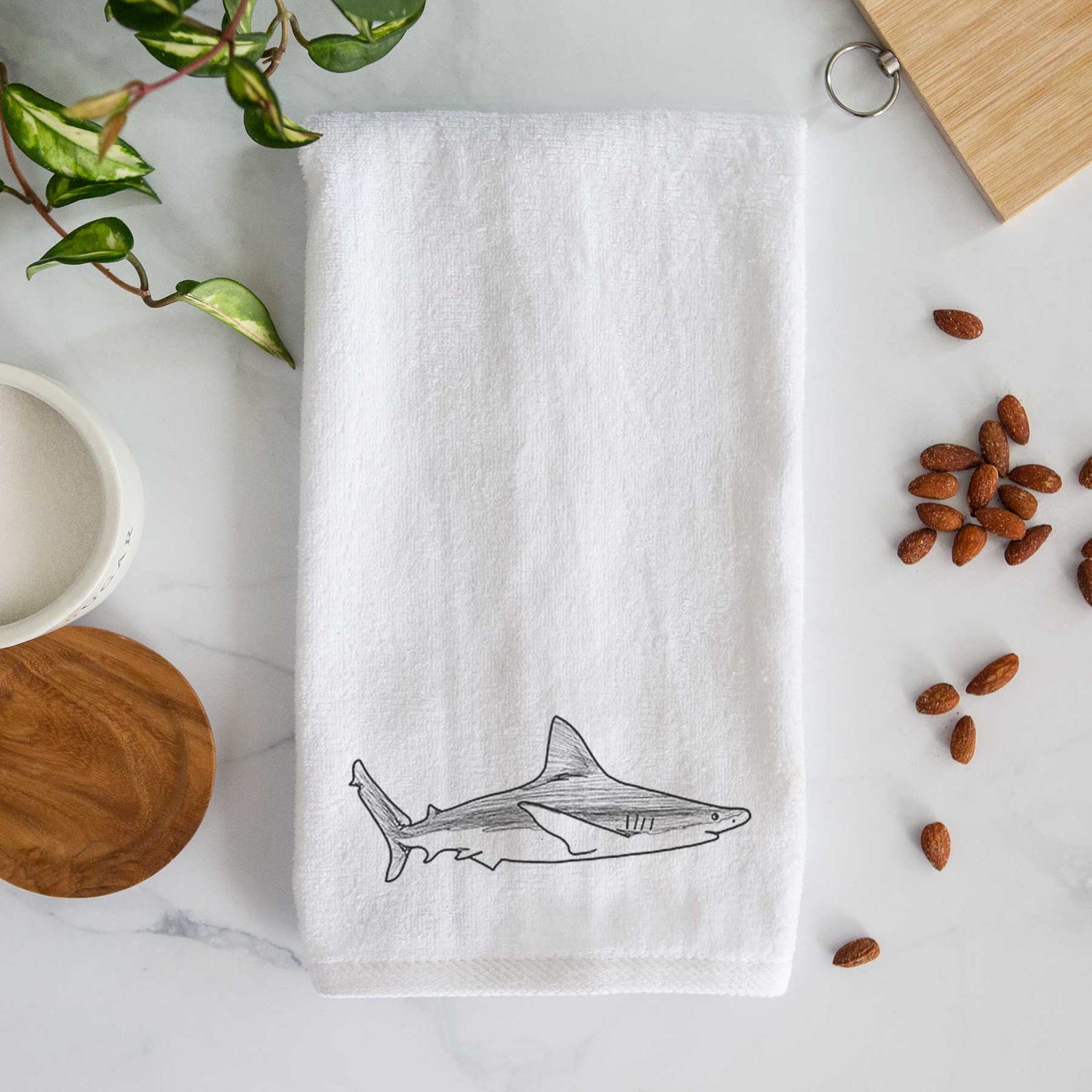 White hand towel printed with a black ink illustration of a silvertip shark swimming in profile.