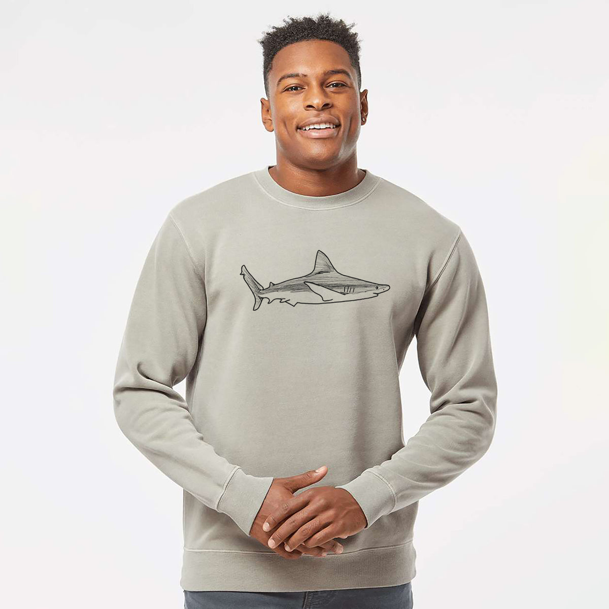 Model wearing a cement grey pigment dyed crewneck sweatshirt printed with a black ink illustration of a silvertip shark swimming in profile.