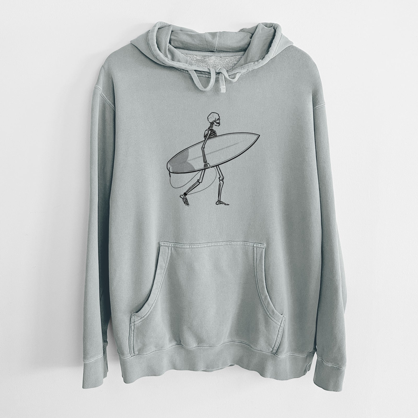 Sage green pigment dyed hoodie laid flat, printed with a black ink skeleton walking while carrying a surfboard.