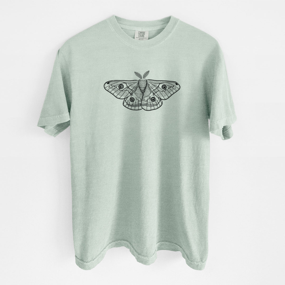 Bay green Comfort Colors t-shirt laid flat, printed with a detailed black ink illustration of a small emperor moth with eyespots on its wings.