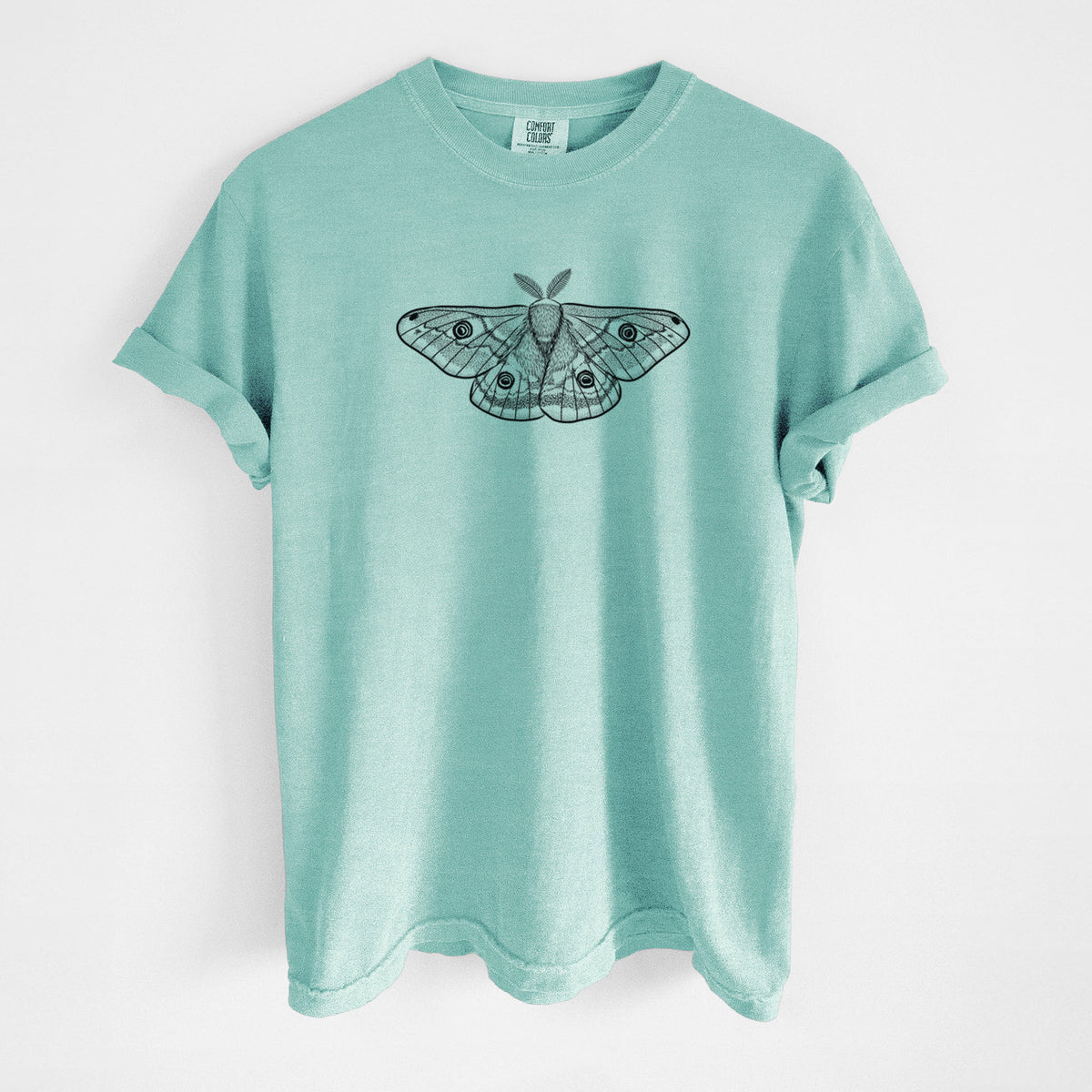 Chalky mint Comfort Colors t-shirt laid flat, printed with a detailed black ink illustration of a small emperor moth with eyespots on its wings.