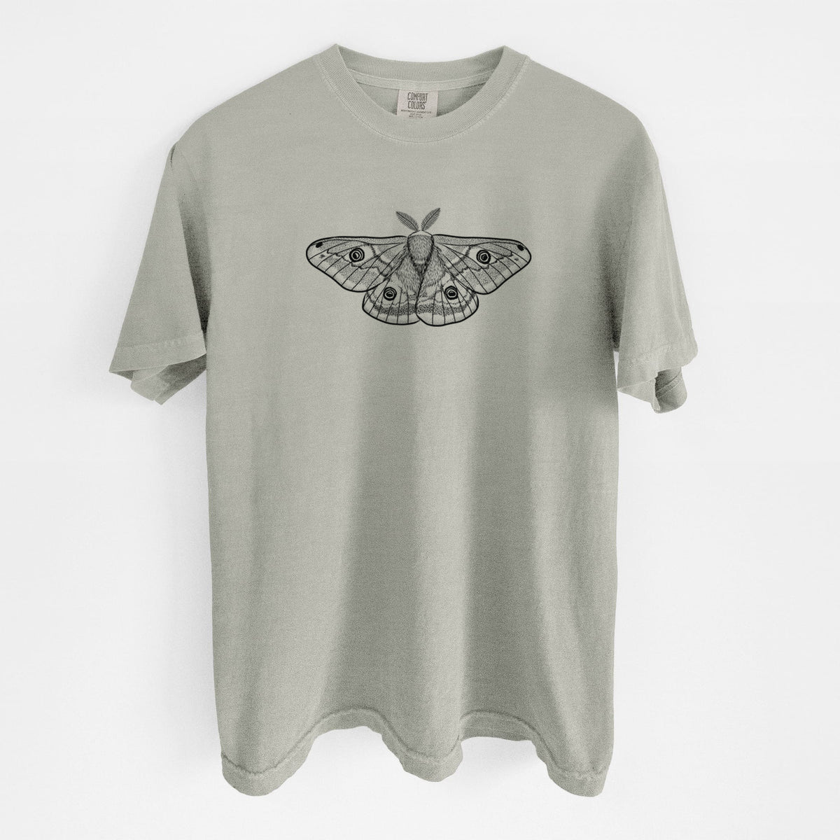 Sandstone beige Comfort Colors t-shirt laid flat, printed with a detailed black ink illustration of a small emperor moth with eyespots on its wings.