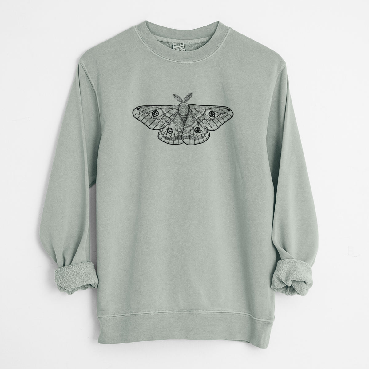 Sage green pigment dyed crewneck sweatshirt laid flat with the sleeves rolled, printed with a detailed black ink illustration of a small emperor moth with eyespots on its wings.