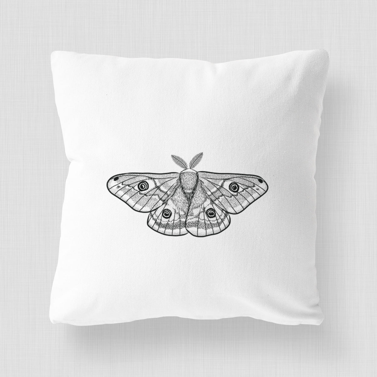 White pillow cover printed with a detailed black ink illustration of a small emperor moth with eyespots on its wings.