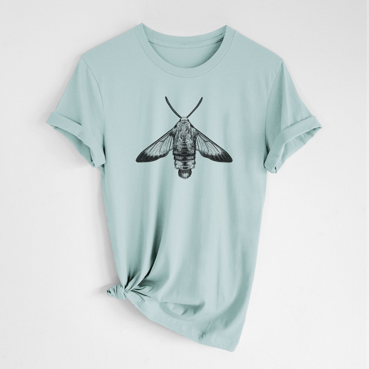 Dusty blue lightweight cotton t-shirt laid flat with the sleeves rolled, printed with a detailed black ink illustration of a snowberry clearwing moth, seen from above.
