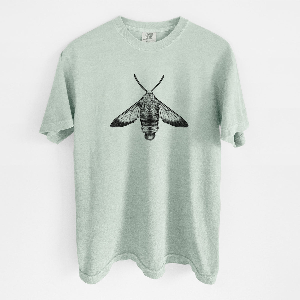 Bay green Comfort Colors t-shirt laid flat, printed with a detailed black ink illustration of a snowberry clearwing moth, seen from above.