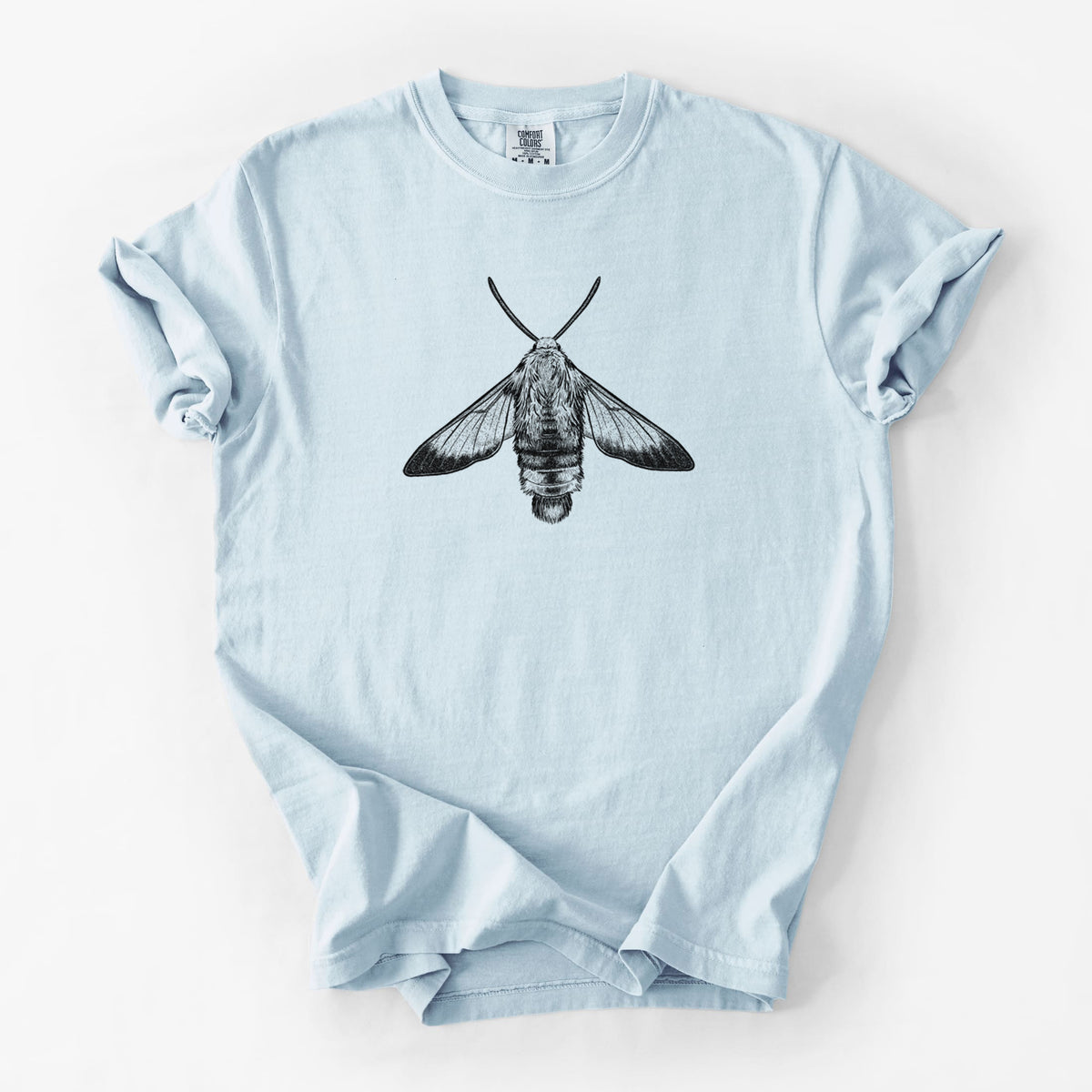 Chambray blue Comfort Colors t-shirt laid flat, printed with a detailed black ink illustration of a snowberry clearwing moth, seen from above.