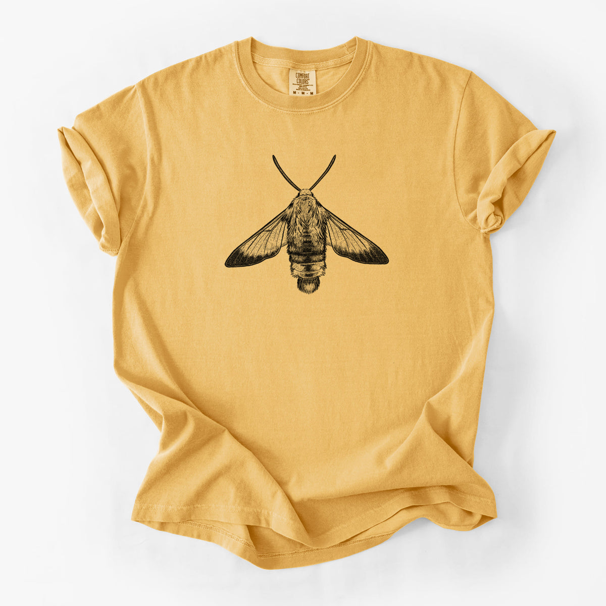Golden wheat yellow Comfort Colors t-shirt laid flat, printed with a detailed black ink illustration of a snowberry clearwing moth, seen from above.